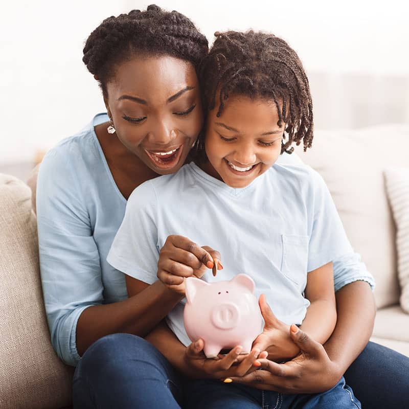 Mother teaching a child to save her pennies